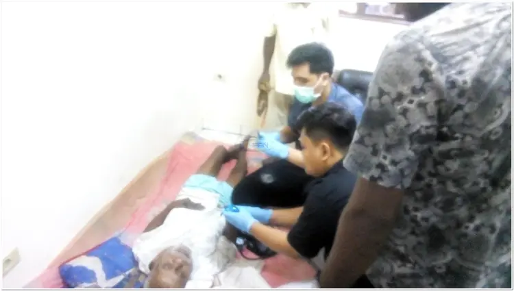 Team medis UNCEN sedang melihat Kakek ini, Kakek ini terbaring kesakitan